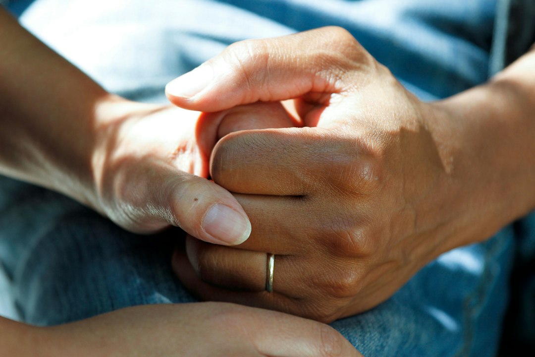 Hands clasped together representing a completed care handoff